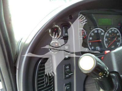 Truck cabin controls and gauges visible through driver's door in Freightliner M2 106 interior.