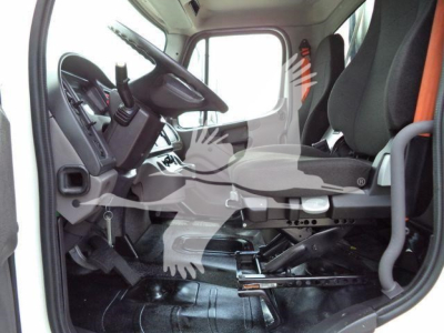 Freightliner M2 106 cab interior showing driver seat and steering wheel with pedals and dashboard