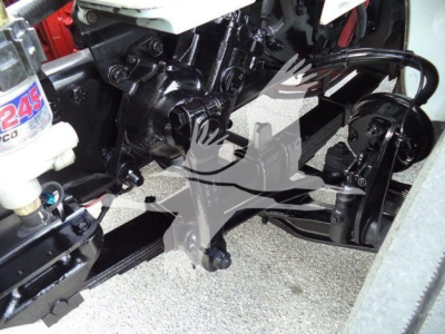 Freightliner M2 106 chassis showing front suspension and hydraulic components with black painted frame and white coolant reservoir cap.