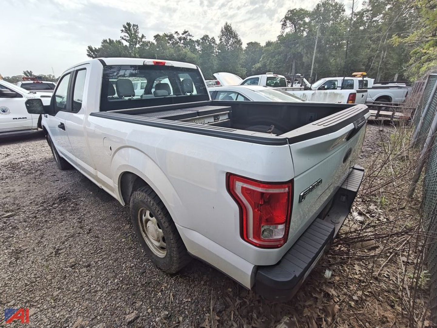 Ford F-150 extended cab pickup truck with bed cover and tailgate in view, white exterior, two-door extended cab, rear quarter and tail lights visible.