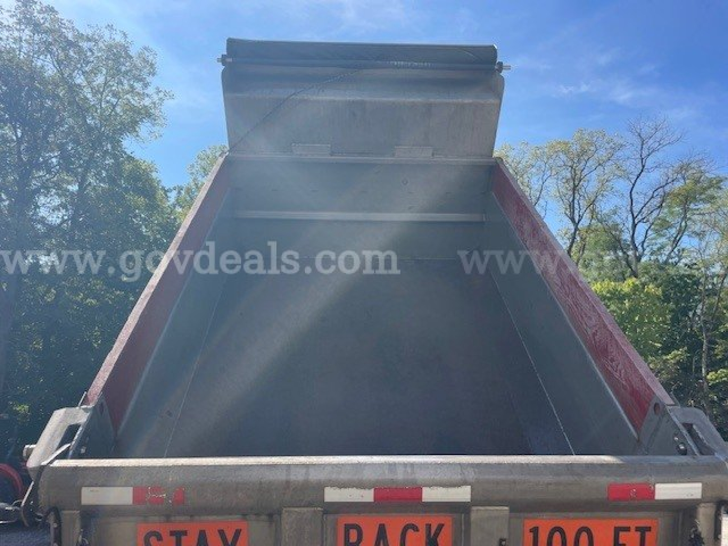 Truck dump bed of a used 2010 International Maxxforce DT 7400, plow category, VIN 1HTWDAAR5AJ232089, stock 24254-14; rear view showing open cargo bed with side rails.
