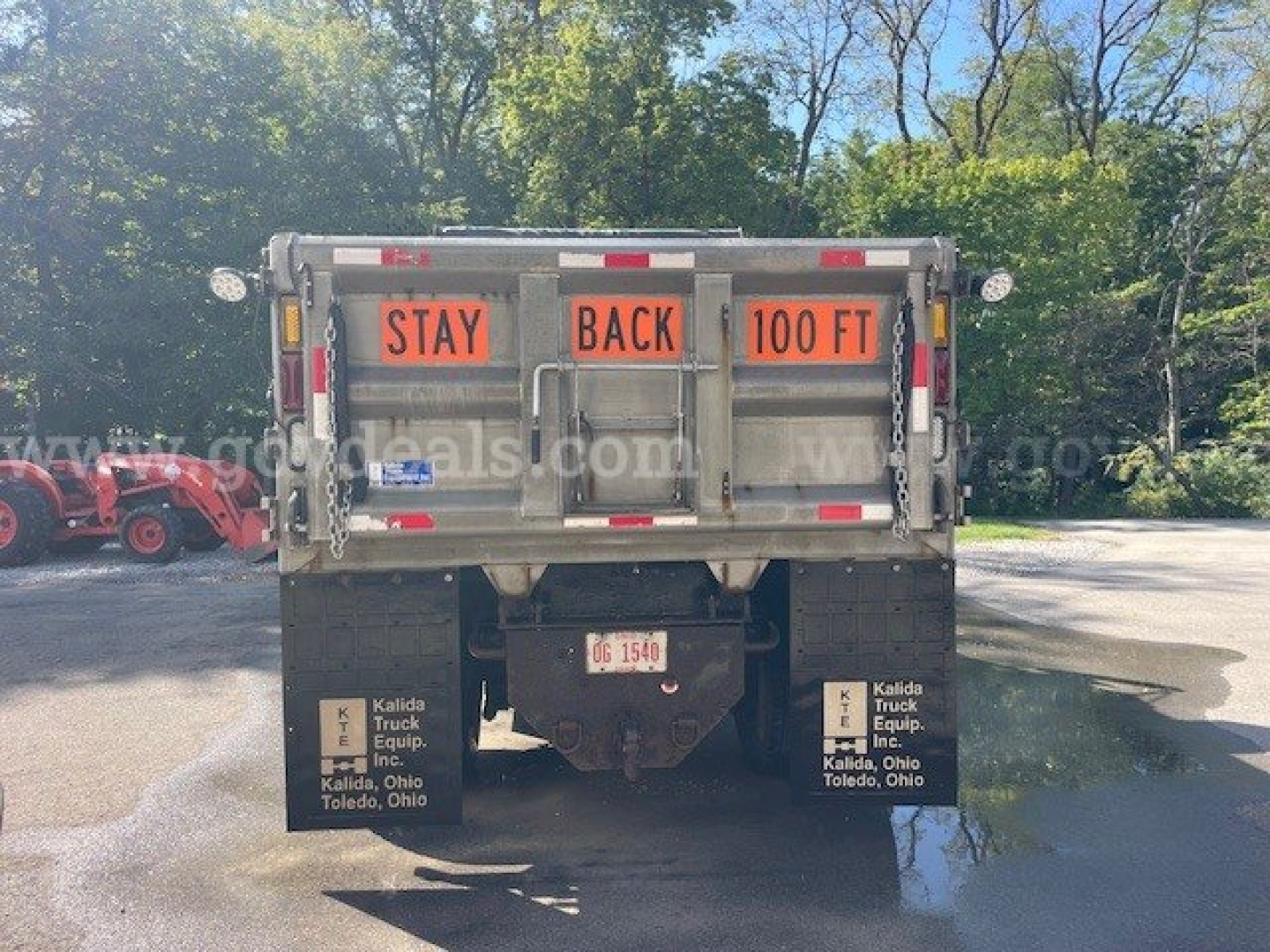 Rear view of truck bed showing 'STAY BACK 100 FT' warning signs and mud flaps with Kalida Truck Equipment branding.