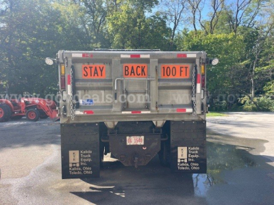 Rear view of truck bed showing 'STAY BACK 100 FT' warning signs and mud flaps with Kalida Truck Equipment branding.