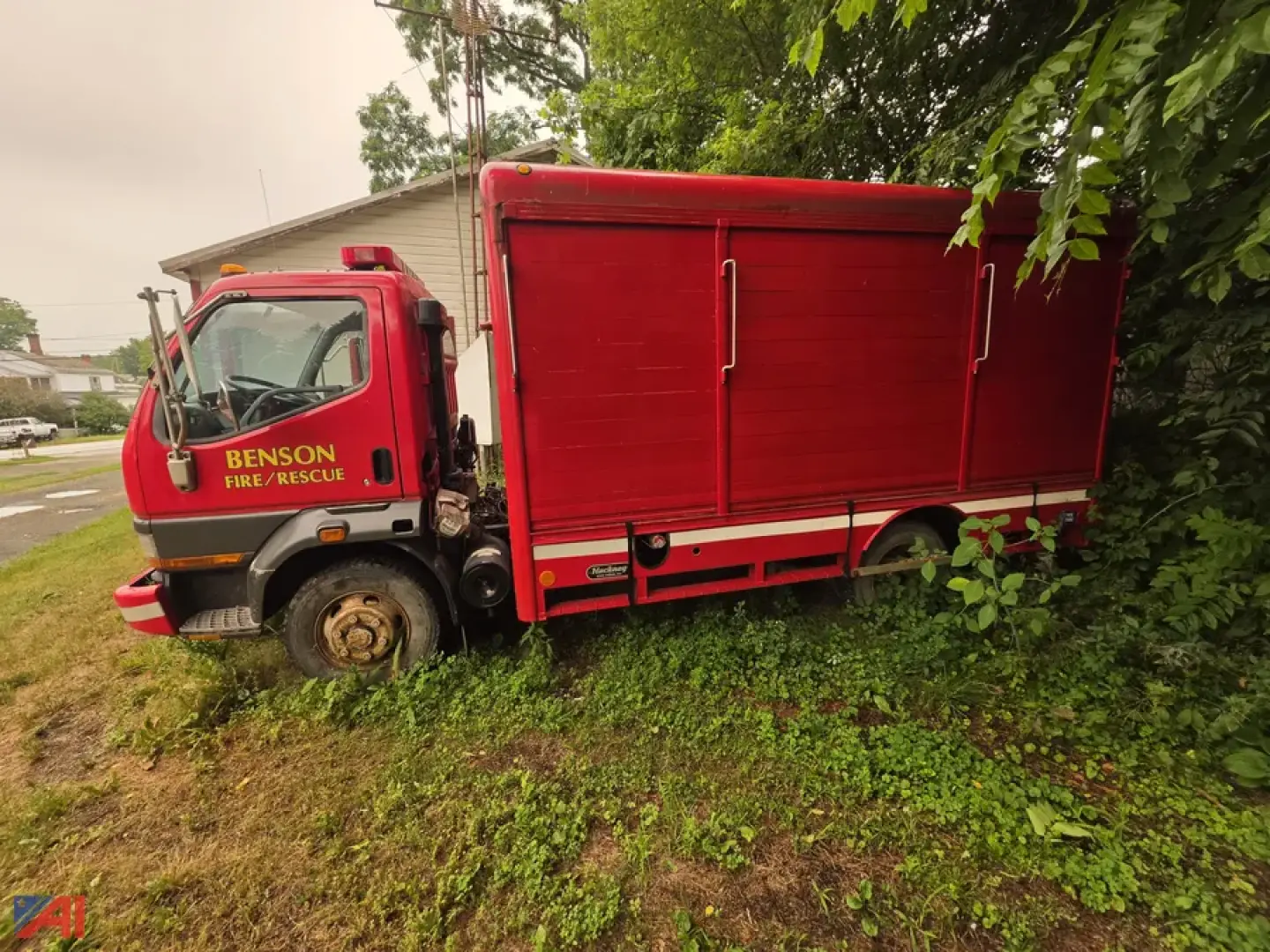 Mitsubishi Fuso FH211 rescue truck in-service, side view, red cab and utility body with 'Benson Fire Rescue' labeling on door.