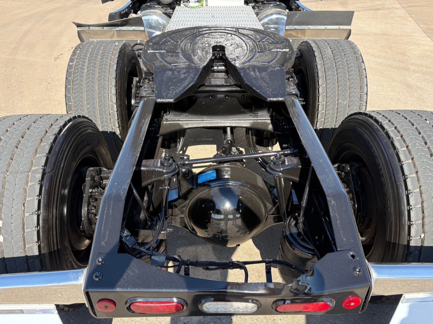 Peterbilt 579 chassis rear view showing drivetrain and suspension with dual rear axles and fifth wheel mount.
