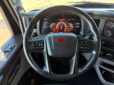 Peterbilt steering wheel and dashboard view in a 2022 Peterbilt 579 cab, with digital instrument cluster and steering wheel controls visible.
