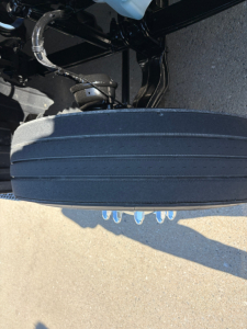 Peterbilt 579 truck undercarriage showing spare wheel and suspension components, with tire and underbelly hardware visible.