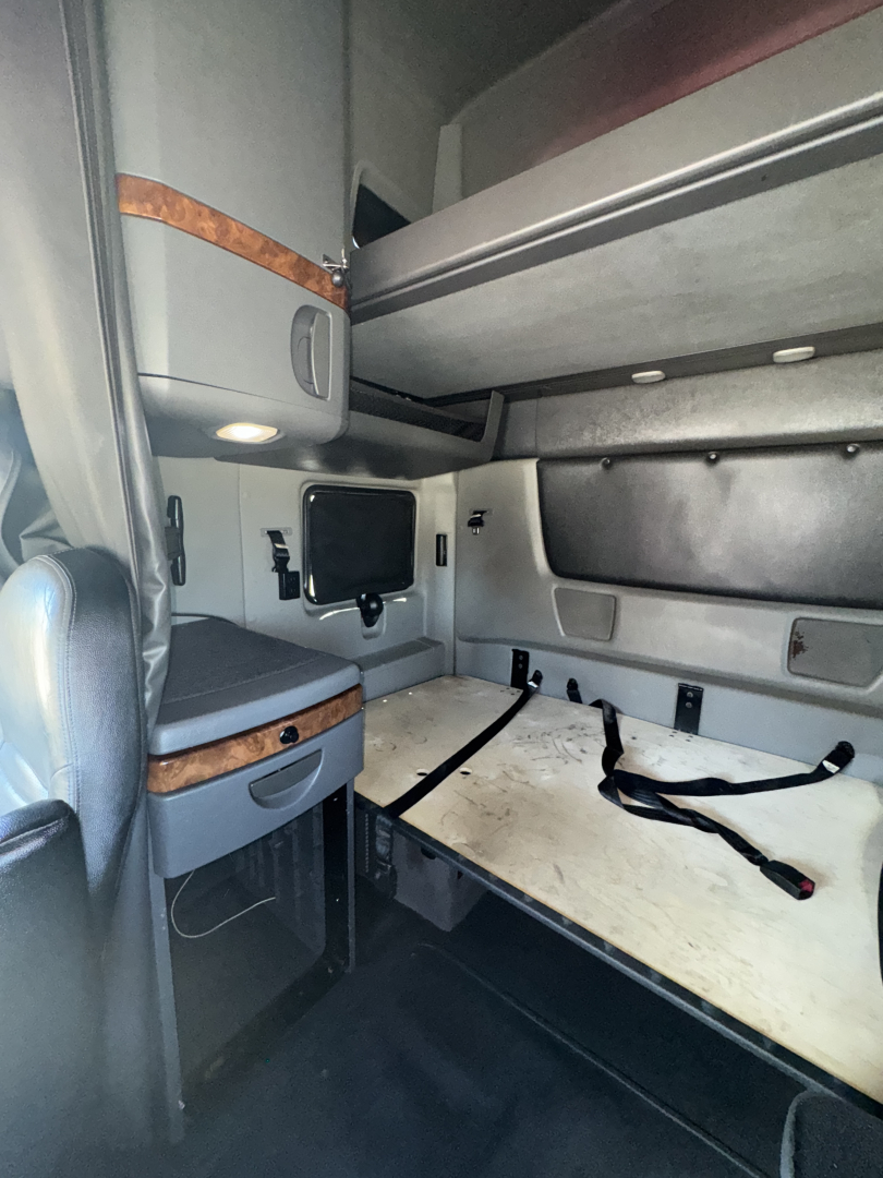 Cabin area of a 2019 International LT625 sleeper with bunk bed area and storage compartments visible.