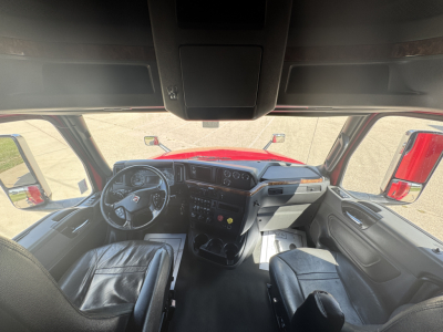 Truck cab interior of a 2019 International LT625 showing steering wheel, dashboard, and seating from driver’s perspective.