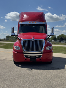 International LT625 truck front view showing chrome grille and red cab with large bumper.