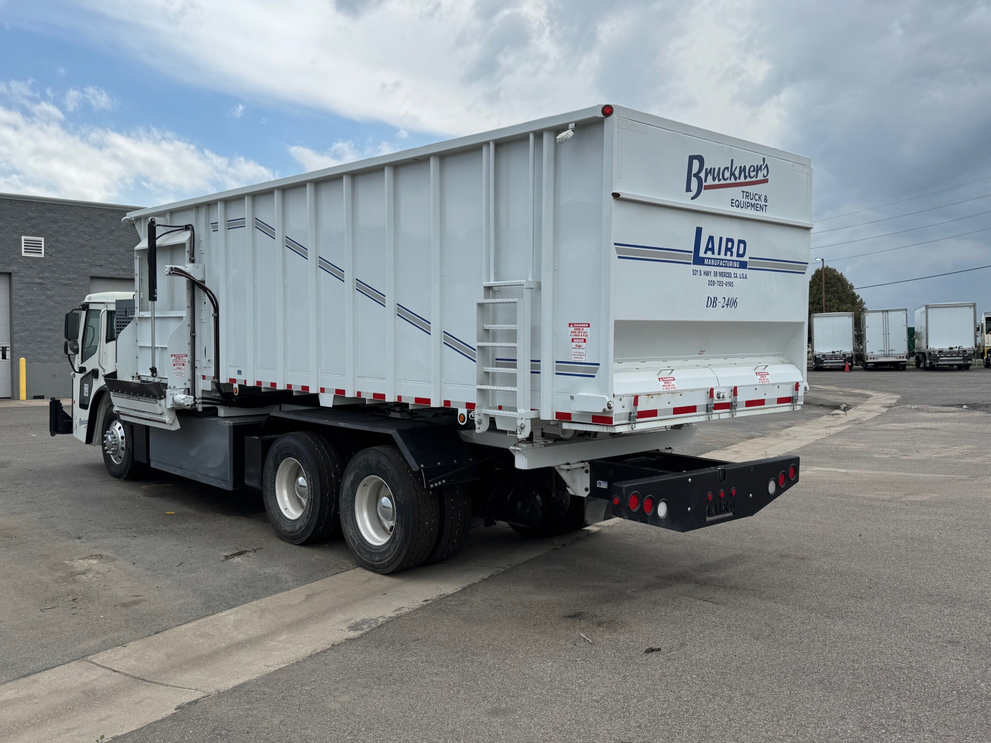 Truck trailer rear and side view showing Mack LR64 BE branding on trailer door and Bruckners Trucking logo.