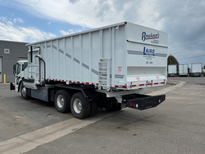 Truck trailer rear and side view showing Mack LR64 BE branding on trailer door and Bruckners Trucking logo.
