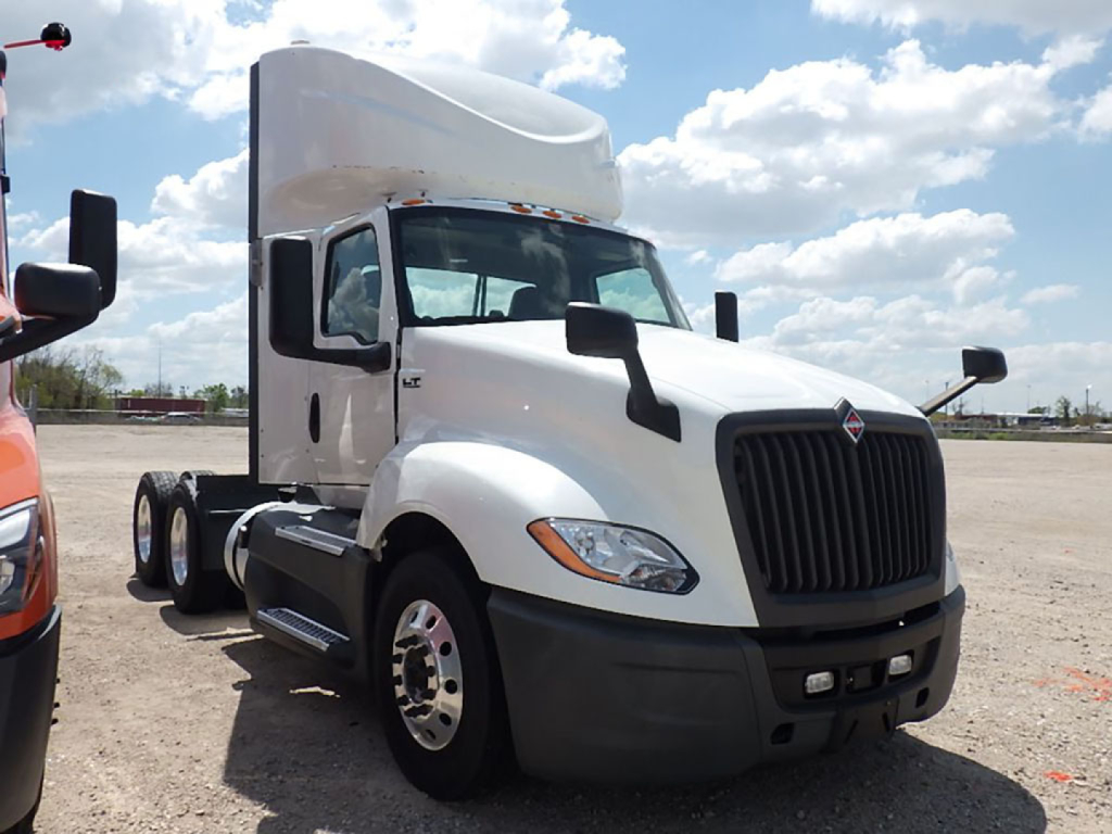 International LT series heavy-duty truck cab and grille showing front view with large black vertical grille and white body tub.