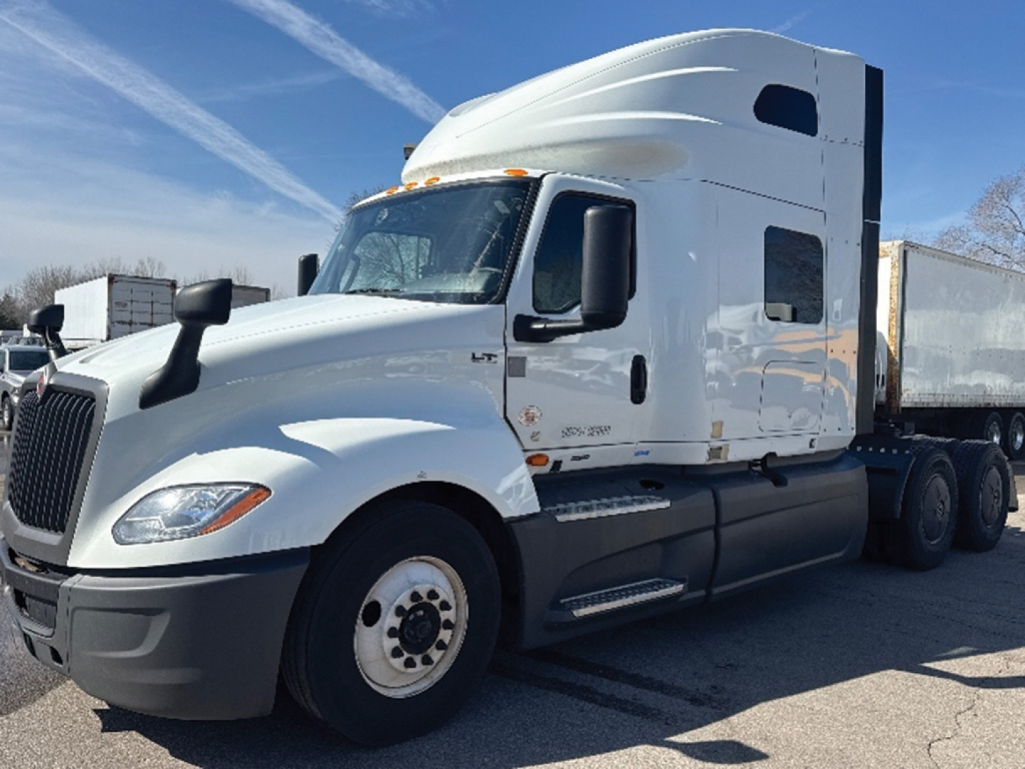 Truck cab and trailer in a parking lot with International LT625 model badge on the side.