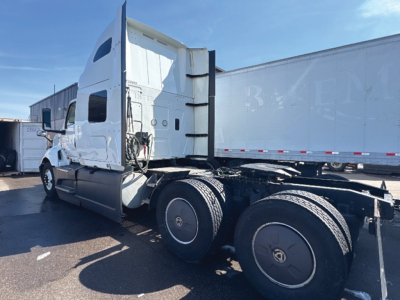 Truck cab and trailer unit showing sleeper cab, International LT625, rear side view with dual rear axles and fifth wheel area visible.