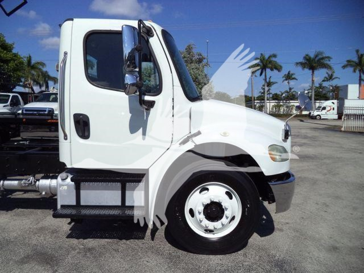 Truck side profile showing 2017 Freightliner M2 106 cab and front wheel, white color, with steps and side mirror visible.