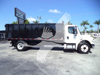 Truck side view of a white 2017 Freightliner M2 106 dump truck with black dump body, under clear sky.