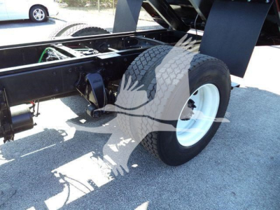 Freightliner M2 106 truck chassis rear view showing wheel, suspension, and frame with dumping bed mechanism.