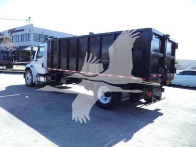 Dump truck shown from rear three-quarter view with black dump bed and white cab, Freightliner M2 106 used vehicle.