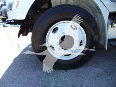 Front wheel of a Freightliner M2 106 dump truck showing wheel, tire, and fender area.