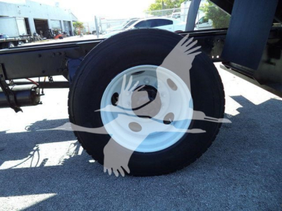Truck wheel close-up on Freightliner M2 106 chassis showing tire and white steel rim.