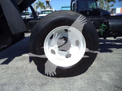 Truck wheel with white rim on Freightliner M2 106 dump chassis showing tire and hub area.