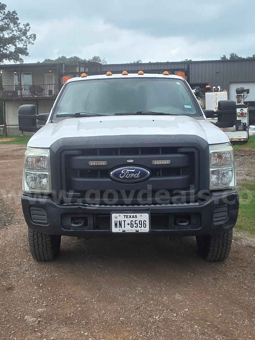 Ford F-350 front view showing grille, bumper, and Texas license plate in a gravel lot.