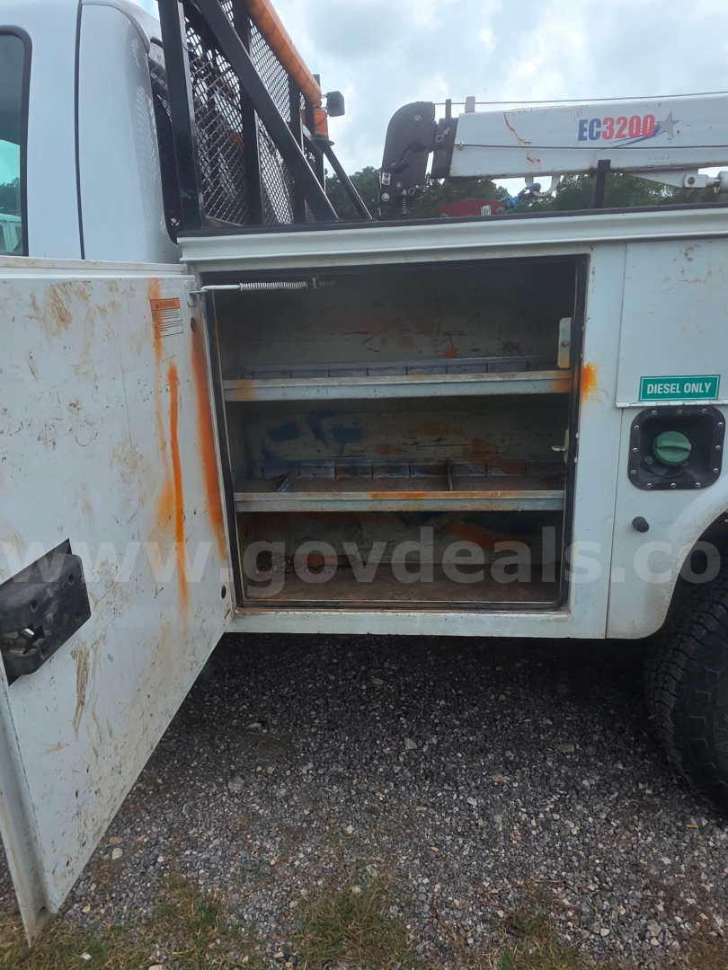Ford F-350 utility truck side compartment with open shelves showing storage drawers and rust marks