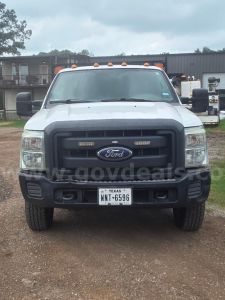 Ford F-350 front view showing grille, bumper, and Texas license plate in a gravel lot.