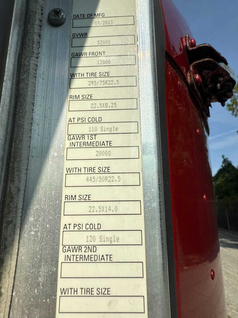 Vehicle data plate on 2014 Kenworth T660 showing GVWR 52000, GAWR FRONT 12000, with tire size 295/75R22.5, rim size 22.5x8.25, cold tire inflation values, and other axle/tire specs.