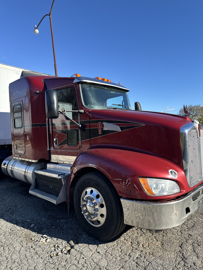 Kenworth T660 semi-truck cab in maroon with chrome fuel tanks and fenders, exterior view showing front and side profile; truck is a 2014 model.