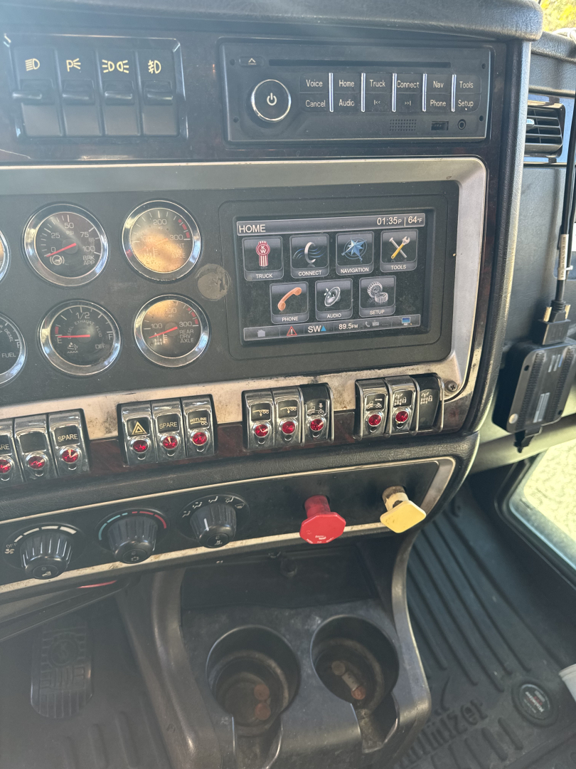 Kenworth T660 truck dash panel with gauges, switches, and digital display; VIN and controls visible.