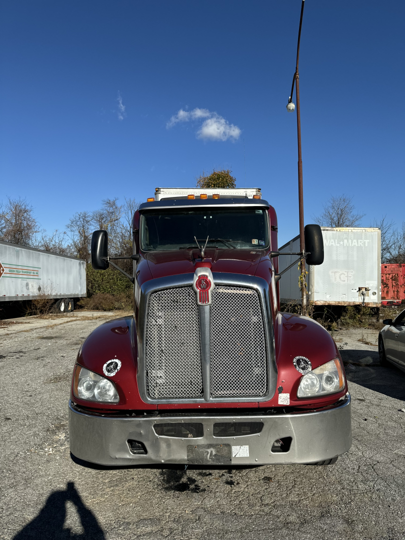Kenworth T660 truck front view with chrome grille and maroon body, headlights, bumper, and side mirrors.