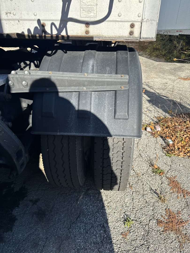 Truck rear dual tires and fender of a 2014 Kenworth T660 sleeper cab tractor, showing wheel area and undercarriage details.