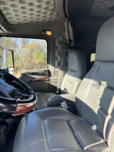 Kenworth T660 truck cabin interior showing driver seat and passenger seat with quilted headliner and dashboard details.