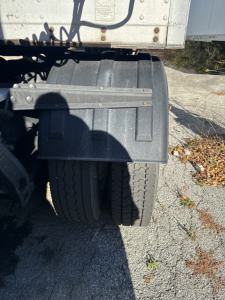 Truck rear dual tires and fender of a 2014 Kenworth T660 sleeper cab tractor, showing wheel area and undercarriage details.