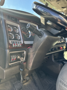 Cab interior of a 2014 Kenworth T660 showing steering column, gauges, ignition area, and dash controls.