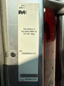 Vehicle data plate on Kenworth T660 showing VIN 1XKAD49X5EJ411318, text 'This vehicle is excluded under 40 CFR 1037.150(g)' and control label, with date 09/18/2013.