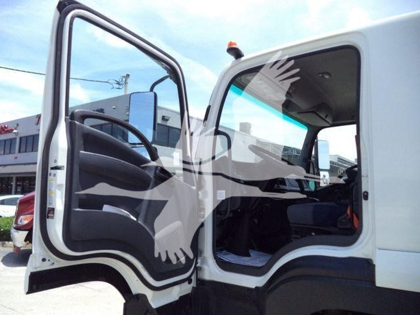 Isuzu truck cabin interior with open driver door, showing steering wheel and seat area.