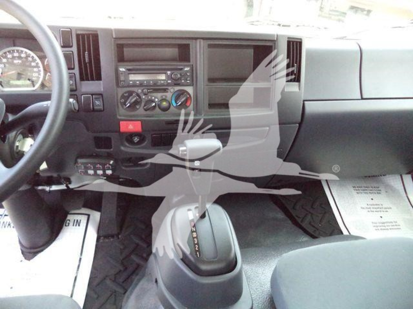 Isuzu FTR interior showing dashboard with steering wheel, center console, climate controls, and gear shifter.