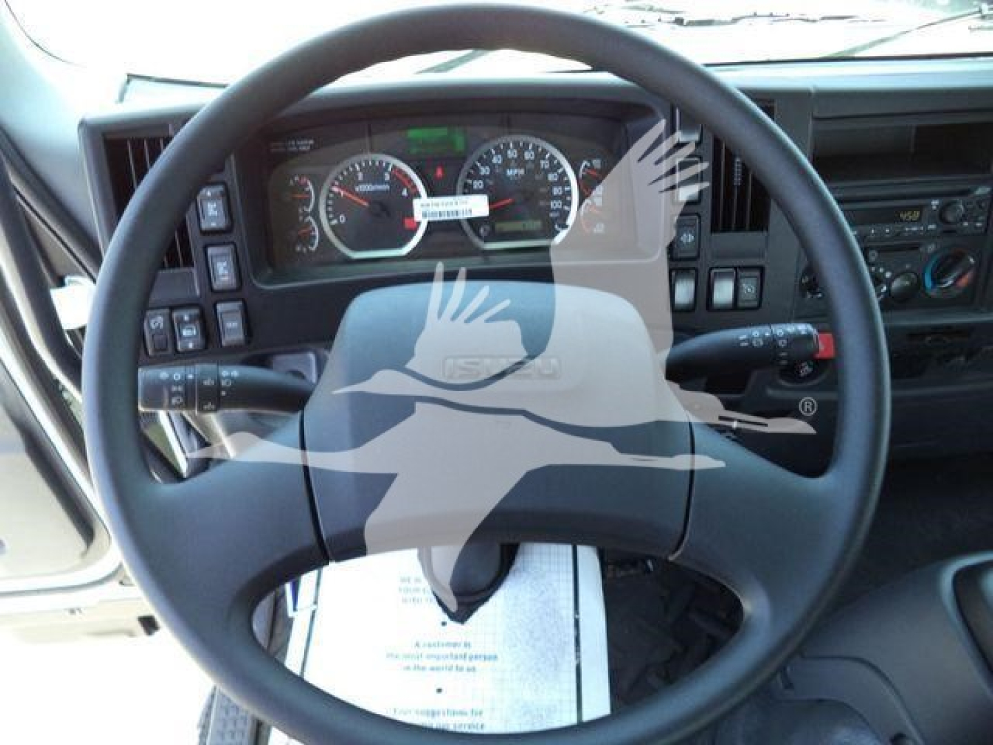 Isuzu truck interior dashboard and steering wheel seen from driver seat showing gauges and controls.