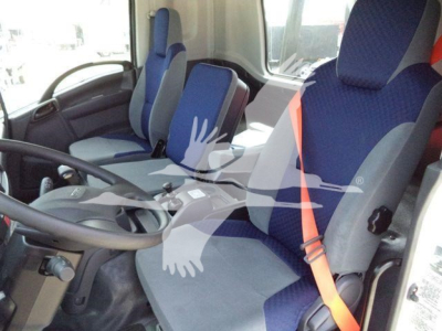 Interior of a 2024 Isuzu NPR/FTR cab with blue seats and orange seatbelt. Steering wheel and dashboard visible.