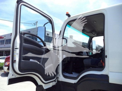 Isuzu truck cabin interior with open driver door, showing steering wheel and seat area.