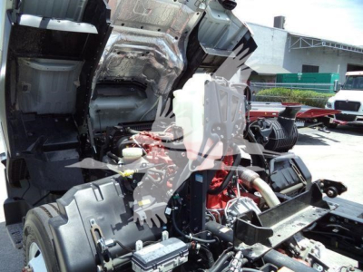 Isuzu FTR truck engine bay showing partial cab removed with engine block and fluid reservoirs visible.
