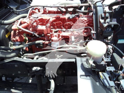 Isuzu FTR engine bay showing red diesel engine and surrounding components.