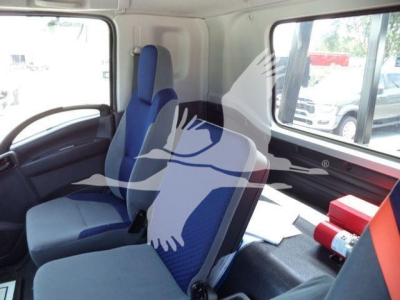 Isuzu truck interior showing blue and gray seats with side windows and cargo area.