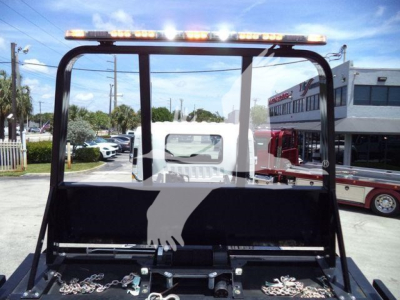 Trucks equipment image showing a Isuzu FTR rollback truck cab back view with a light bar on the top, rear frame and hooks, and a towing apparatus visible in the bed.