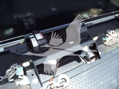 Isuzu truck hitch area with winch and label plates visible in the bed; hardware and chain present
