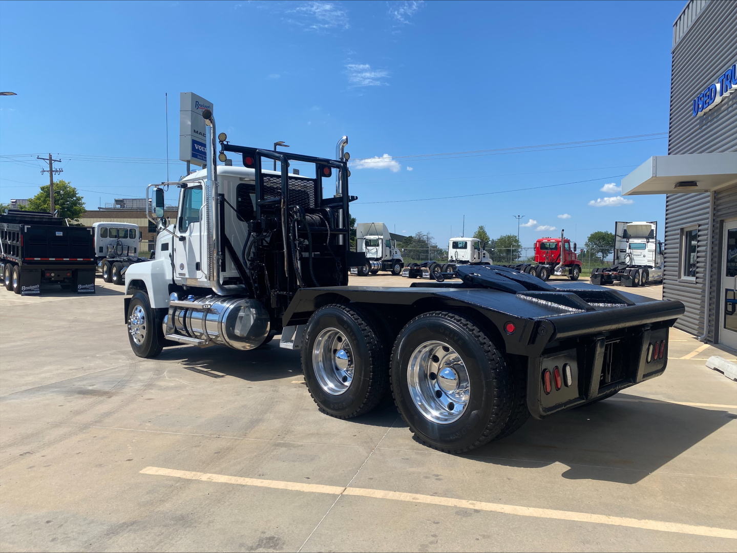 Mack PI64T truck chassis with dual rear axles and winch setup seen from left rear angle.