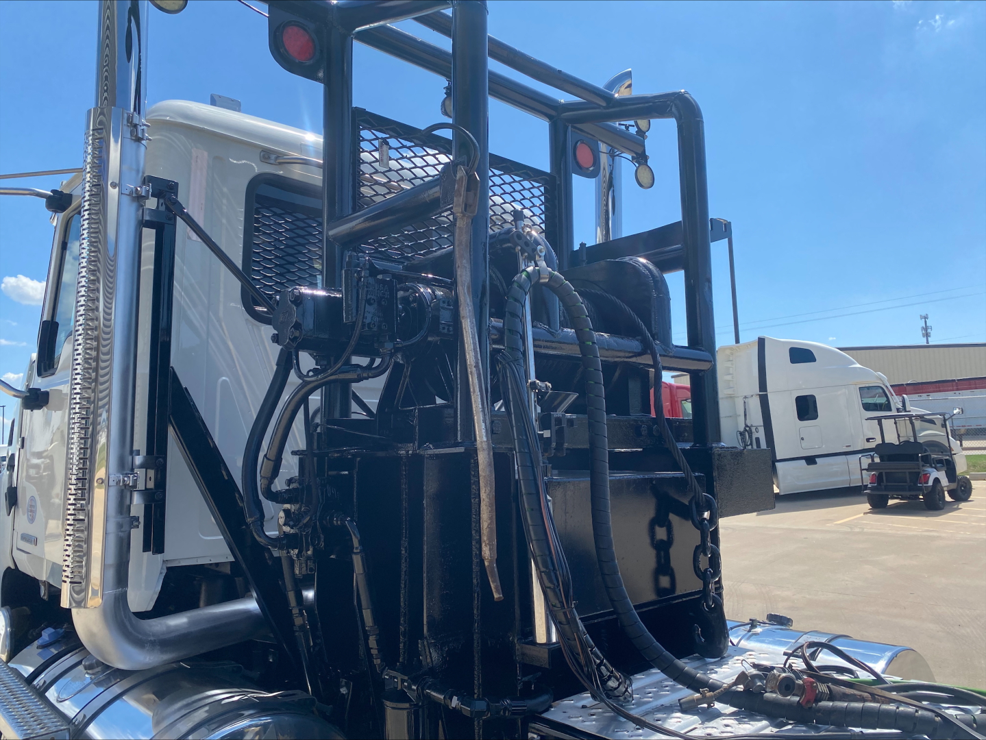 Mack PI64T truck cab and winch setup with hydraulic lines and control levers visible in the rear, components and frame in view.